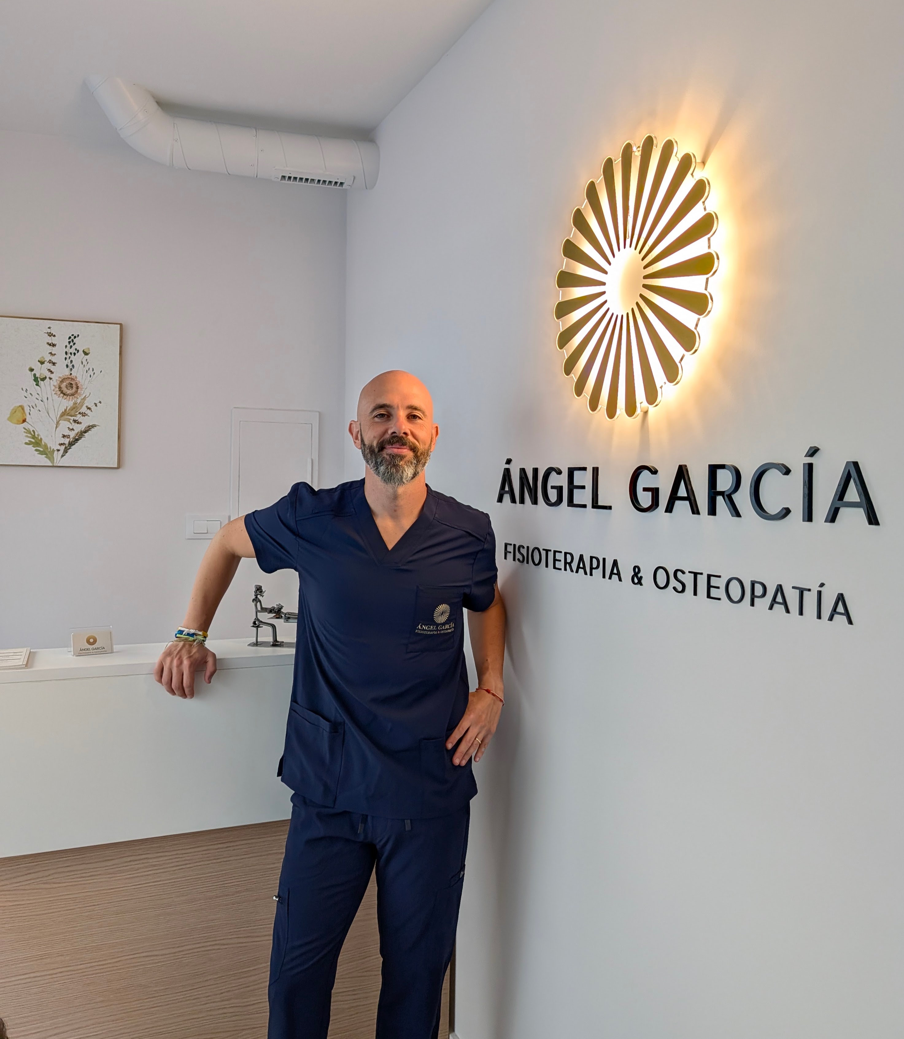 Ángel García junto al logo de su clínica en Vigo